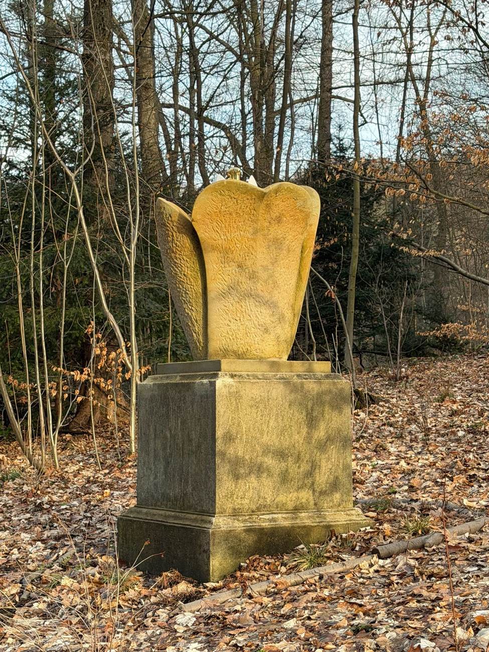 Ein Klangobjekt aus Stein steht still im herbstlichen Wald